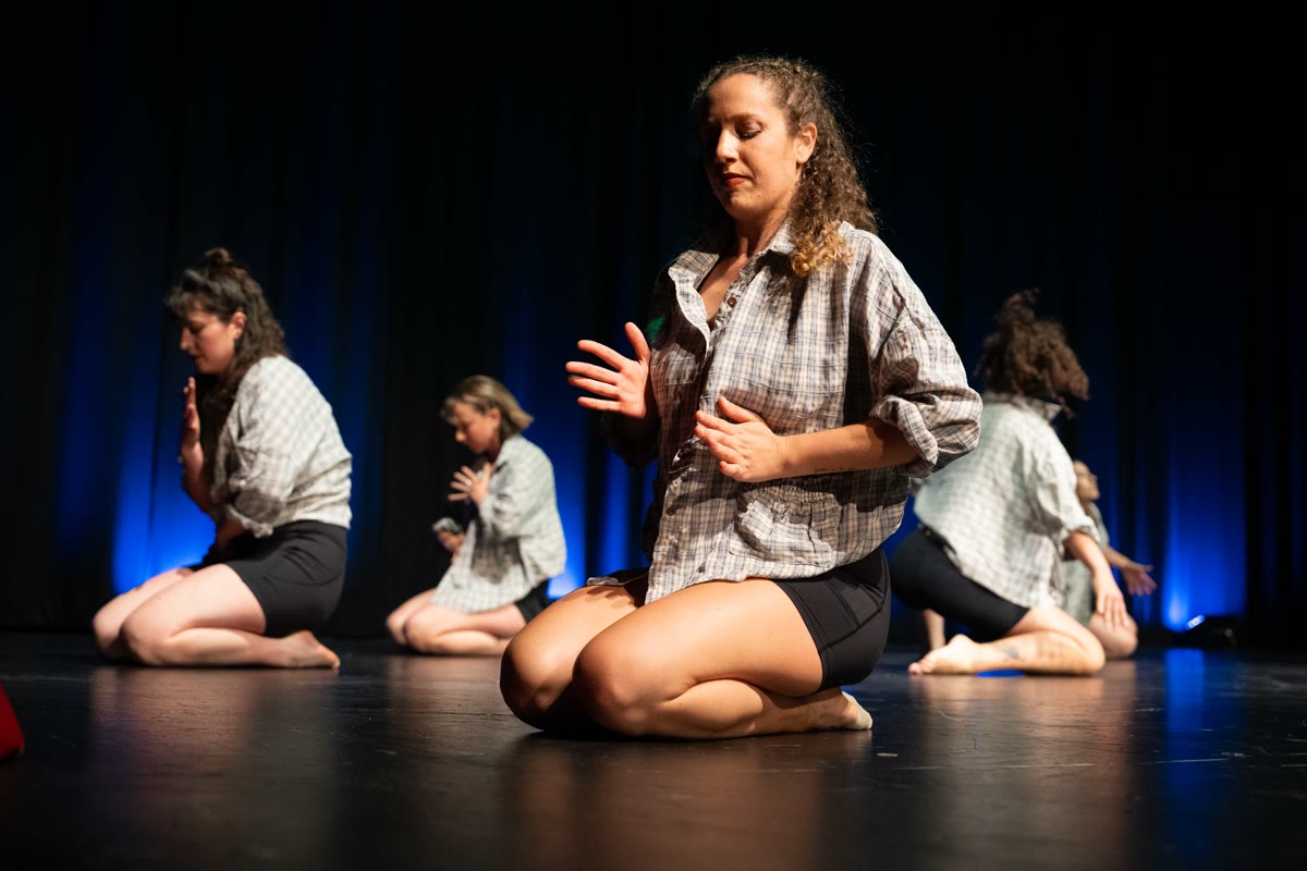 QTC dancers kneeling on stage